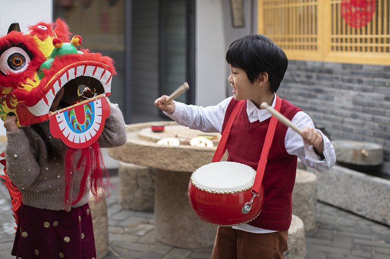 快乐的兄妹俩在院子里舞狮子图片下载