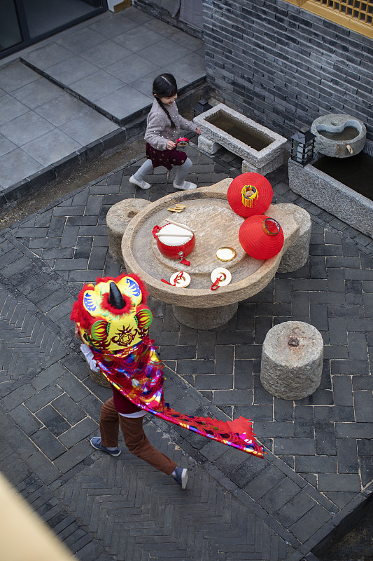 快乐的兄妹俩在院子里舞狮子图片下载