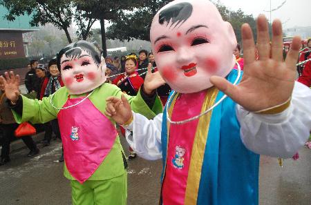 图文：“大头娃娃”表演队在街头行进