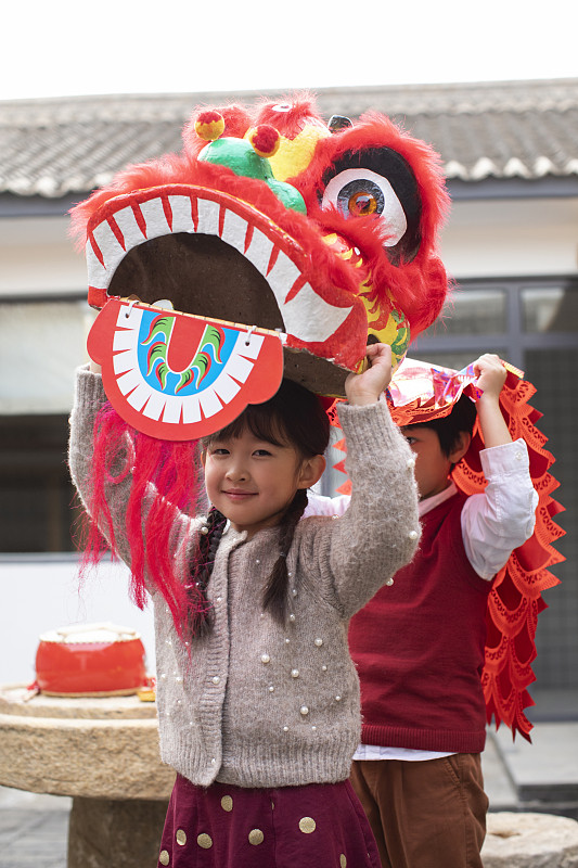 快乐的兄妹俩在院子里舞狮子图片下载
