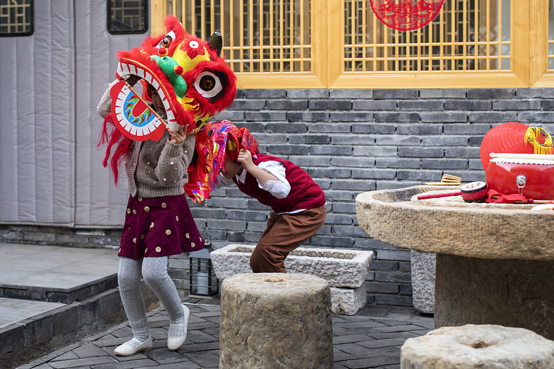 快乐的兄妹俩在院子里舞狮子图片下载